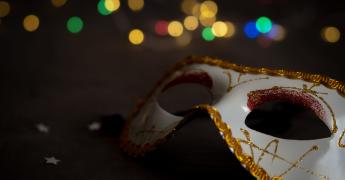 Karnawałowa maska na tle kolorowych światełek.